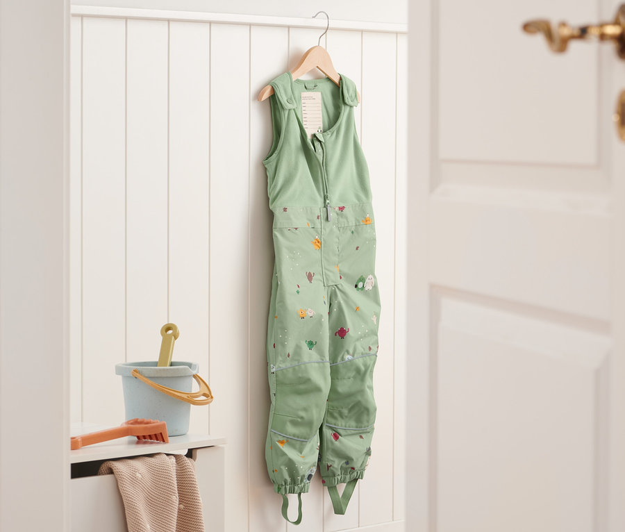 Pantalon de pluie thermique vert suspendu.