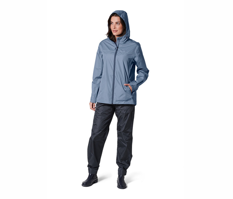 Femme posant dans une veste de pluie unisexe bleue.
