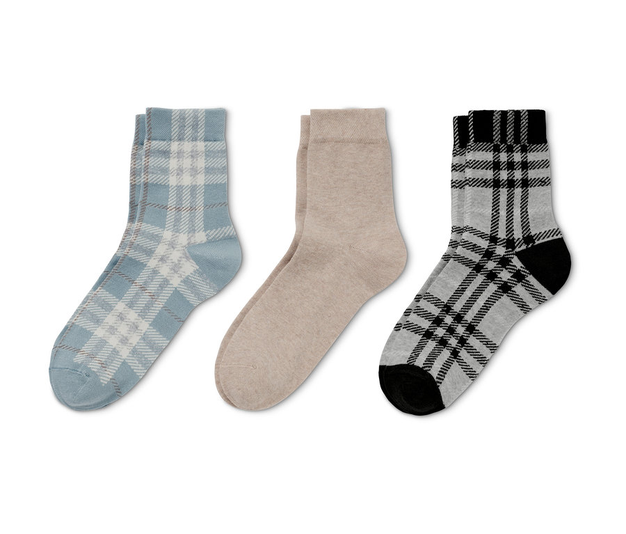 Trois paires de chaussettes : bleu clair à carreaux, beige et gris à carreaux avec pointe et talon noirs.