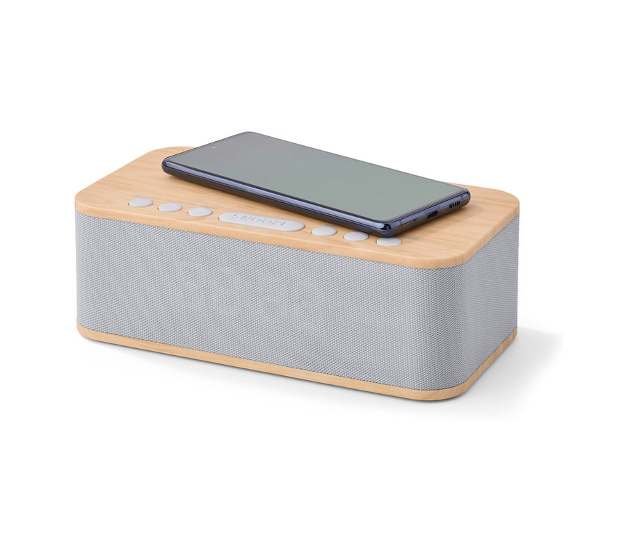 Téléphone portable posé sur un réveil avec fonction de chargement sans fil et Bluetooth®.