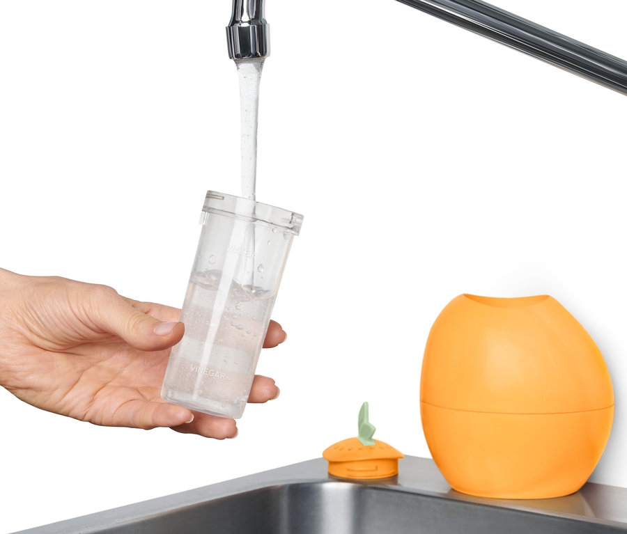 Une main remplit d'eau un nettoyeur à micro-ondes.