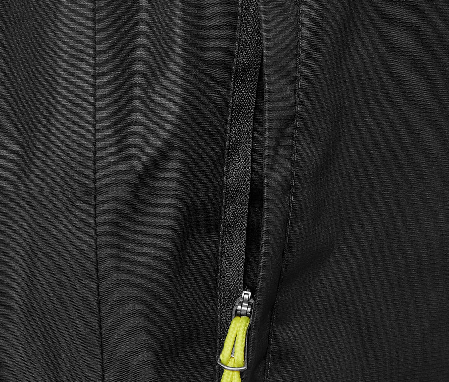 Gros plan sur un pantalon de pluie noir avec une poche zippée et un cordon jaune.