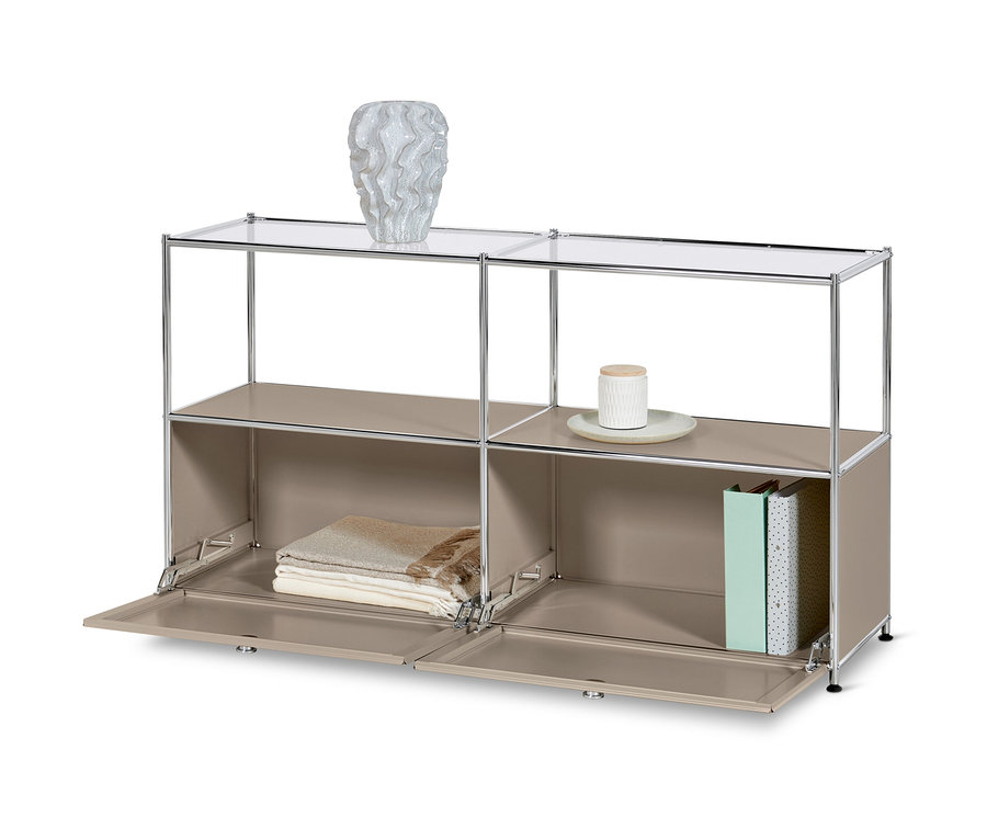 Un buffet en métal « CN3 » à 2 abattants et étagères en verre, taupe. Un vase est posé sur l'étagère supérieure et des couvertures et des livres sur l'étagère inférieure.
