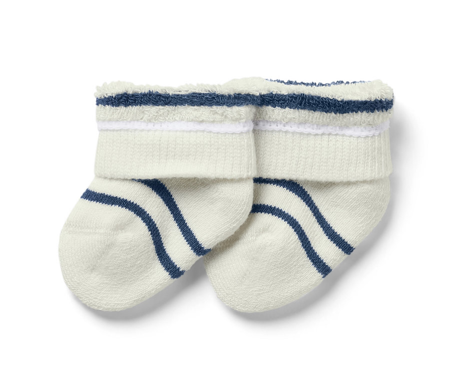 Deux paires de chaussettes blanches pour bébé avec des rayures bleues.