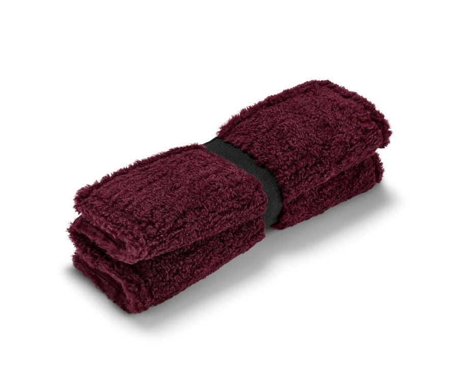 Coussin d’assise thermique pliable bordeaux maintenu par un élastique noir.