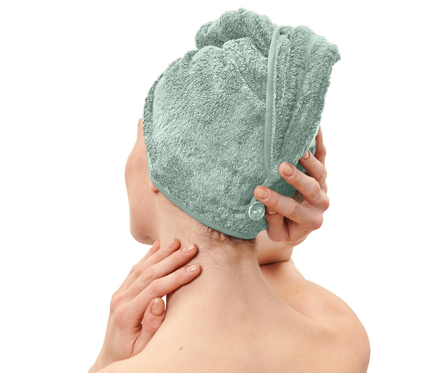 Femme mettant une serviette turban bleu clair.