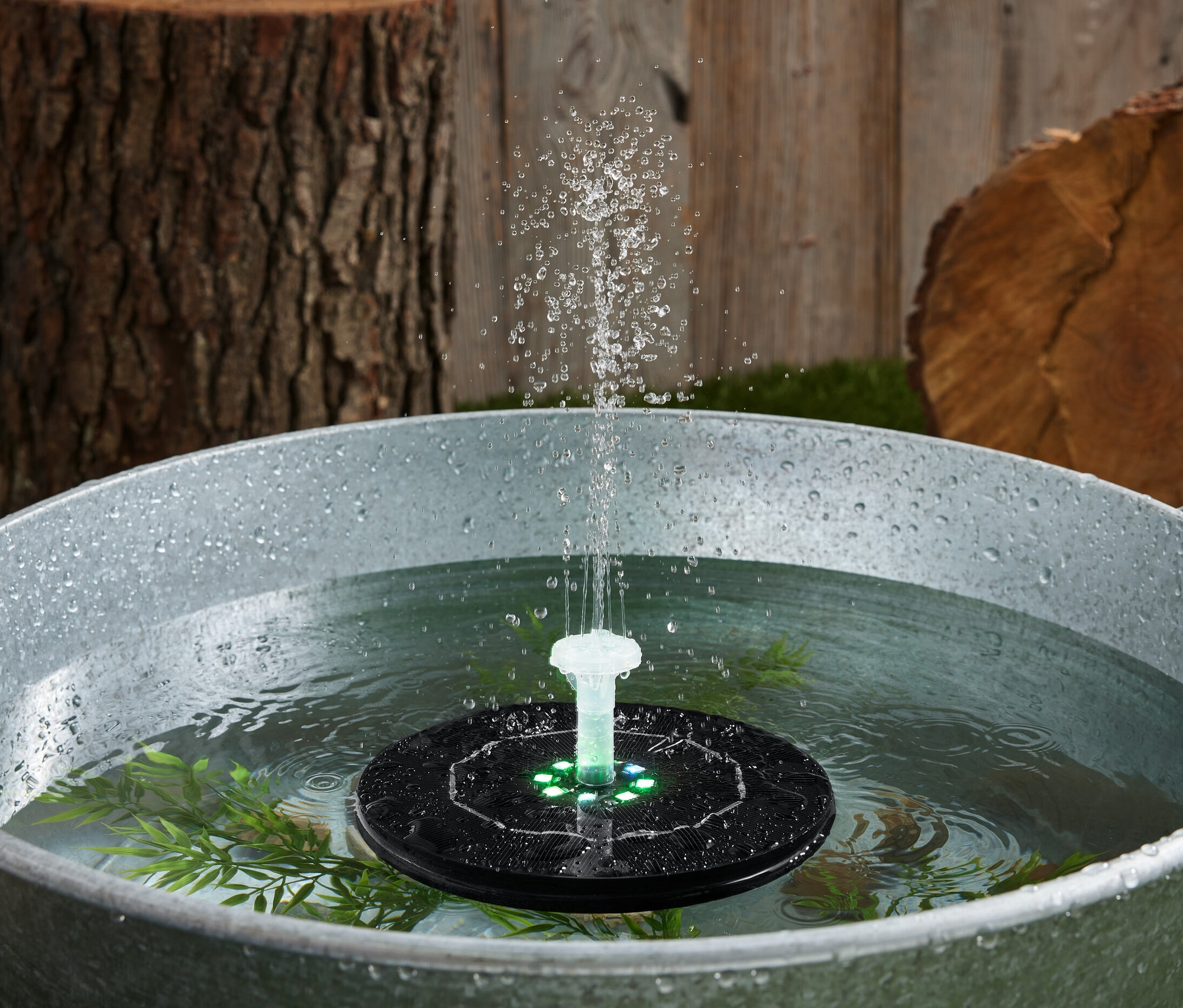 Fontaine flottante à énergie solaire avec éclairage dans une baignoire remplie d'eau.