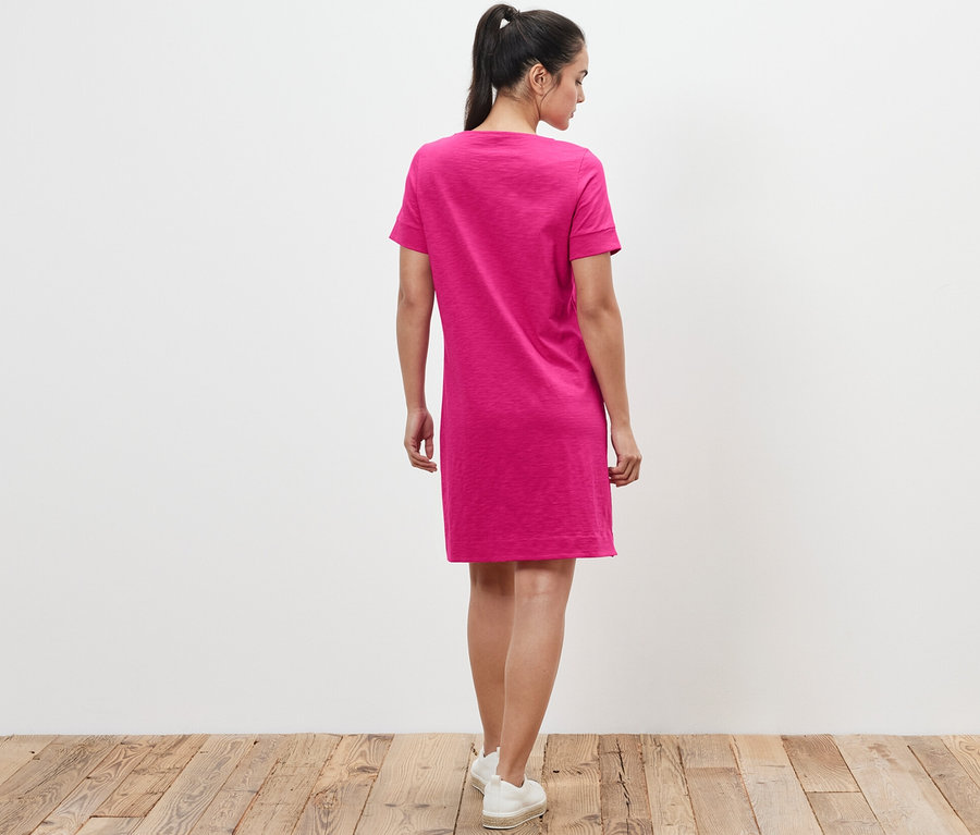 Femme vue de dos portant une robe en jersey rose.