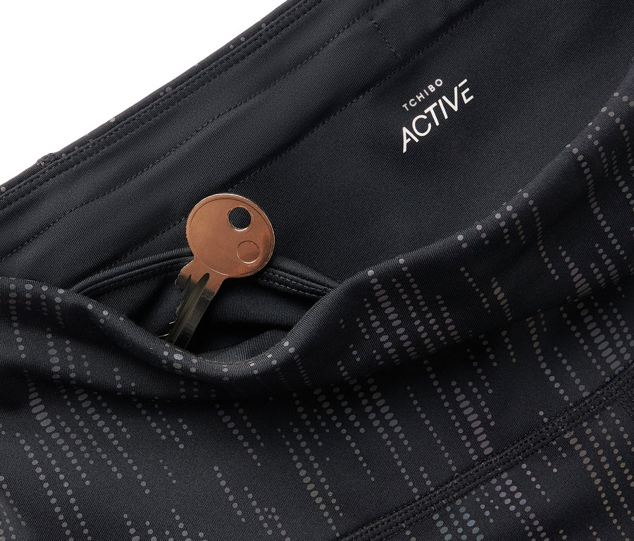 Détail d'un legging noir Tchibo Active avec une clé dans la poche.