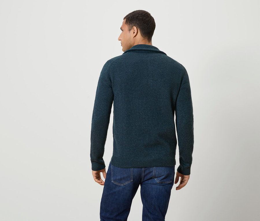 Homme de dos, portant un pull bleu foncé et un jean.