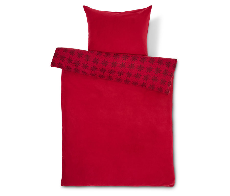 Linge de lit rouge avec étoiles et oreiller.