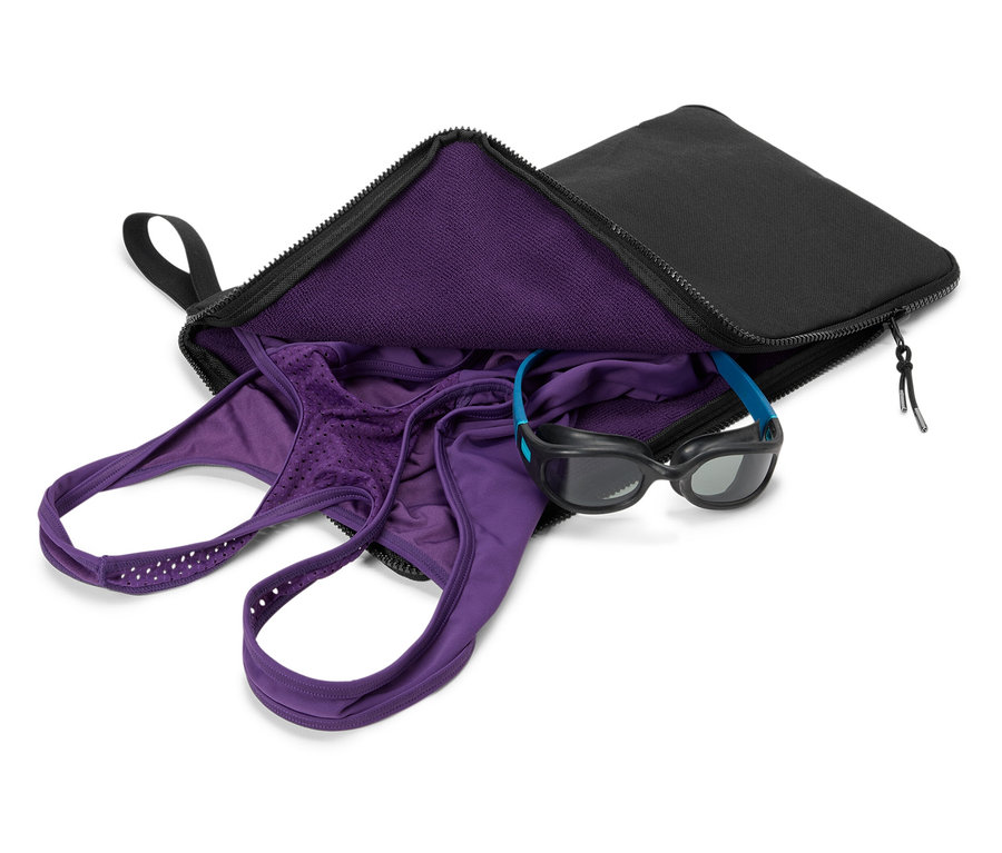 Maillot de bain violet et lunettes de natation dans un sac noir.
