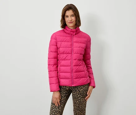 Femme posant en doudoune rose et pantalon animalier.