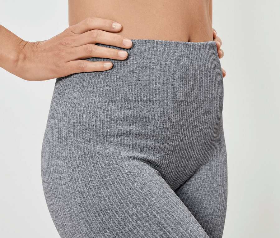 Femme posant en leggings côtelés gris.