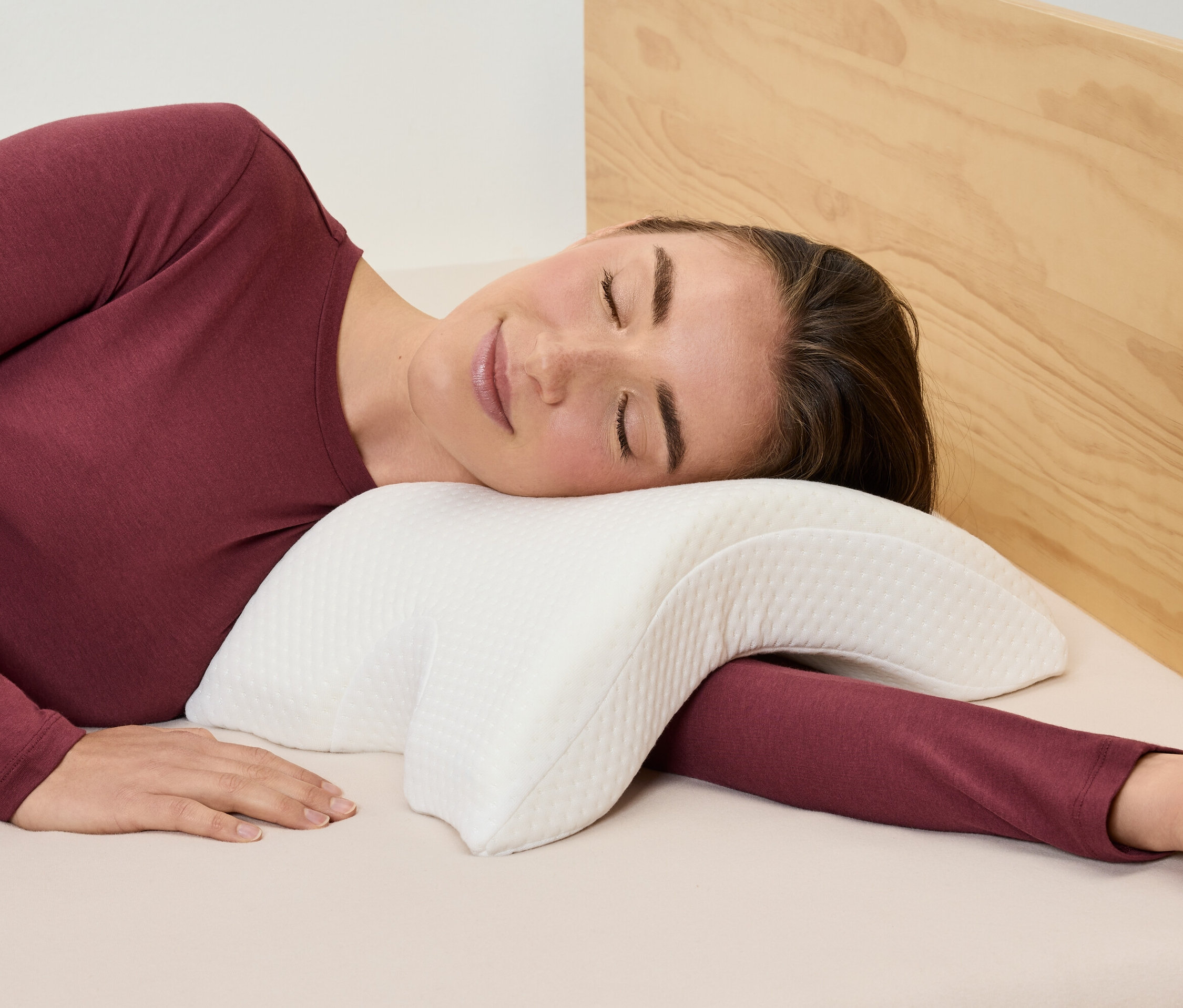 Femme allongée sur le côté sur un oreiller blanc.