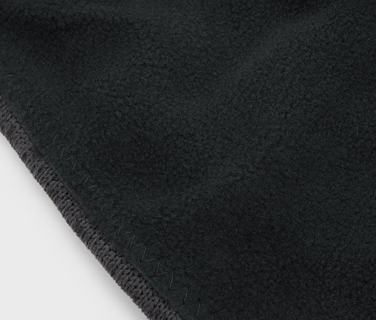 Gros plan sur un tissu noir avec une bordure grise.