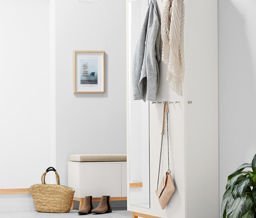 À l'intérieur, une armoire de couloir. Une veste et une écharpe sont accrochées au mur.