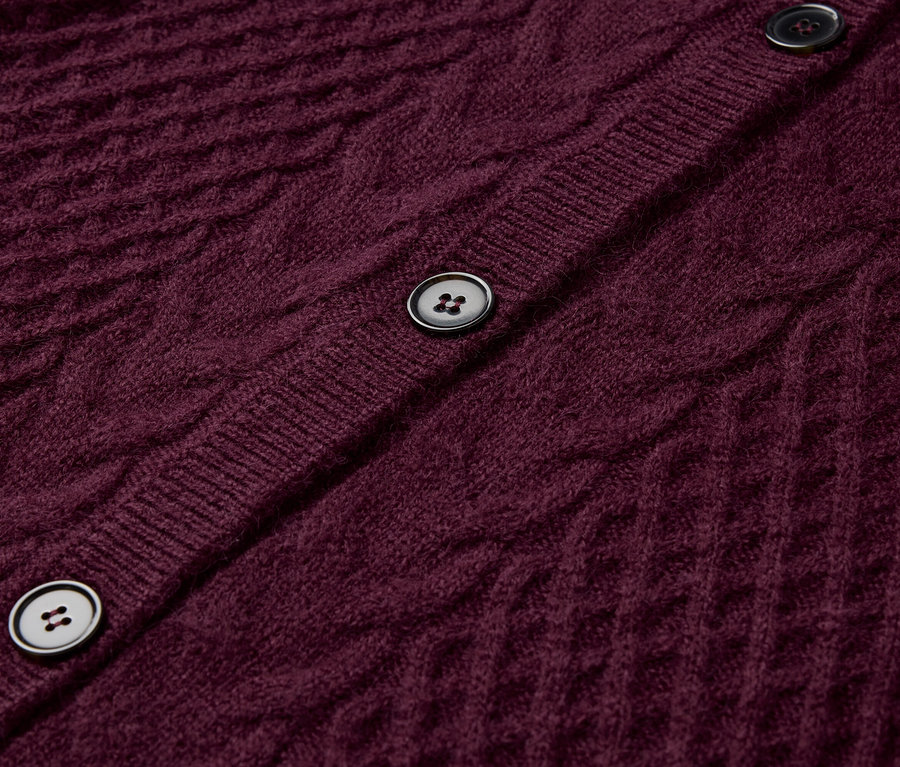 Gros plan sur un cardigan bordeaux en tricot avec des boutons.