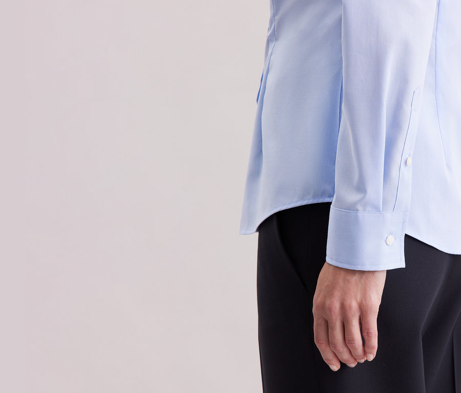 Gros plan d'une personne portant un chemisier bleu clair Slim Fit non iron Seidensticker.