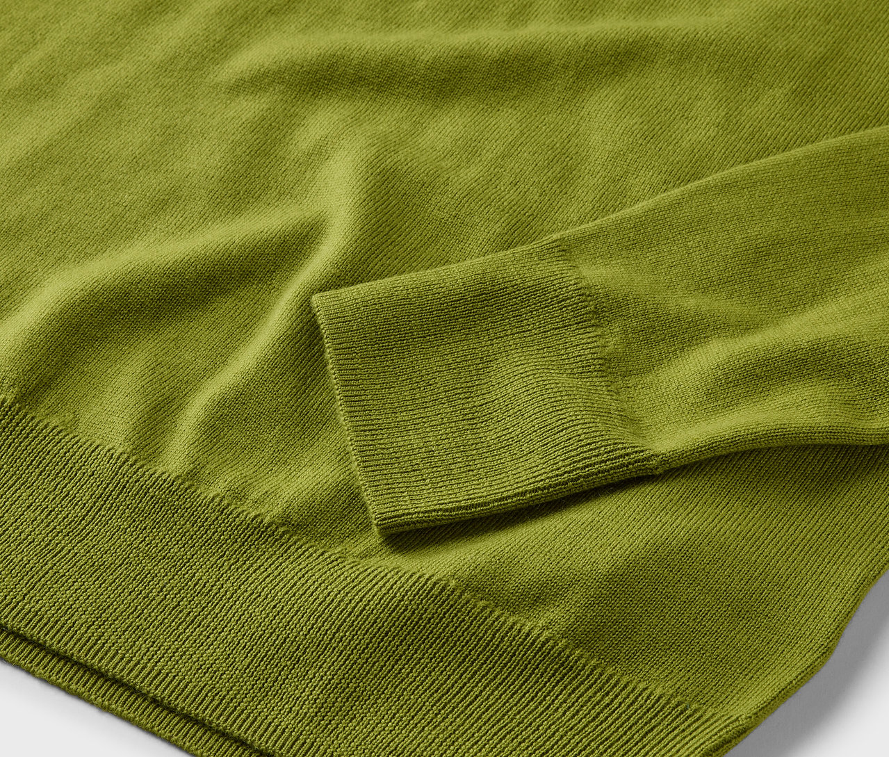 Détail d'un pull en maille fine mérinos vert clair.