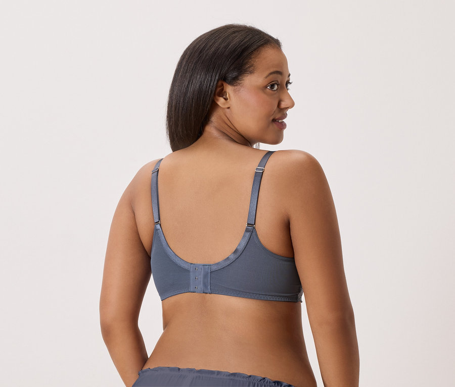 Vue arrière d'une femme aux cheveux foncés portant un soutien-gorge et une culotte gris.