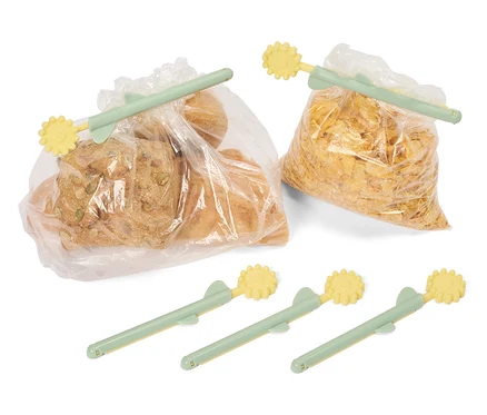 Du pain et des cornflakes sont fermés par des bâtonnets de conservation vert clair et jaunes.