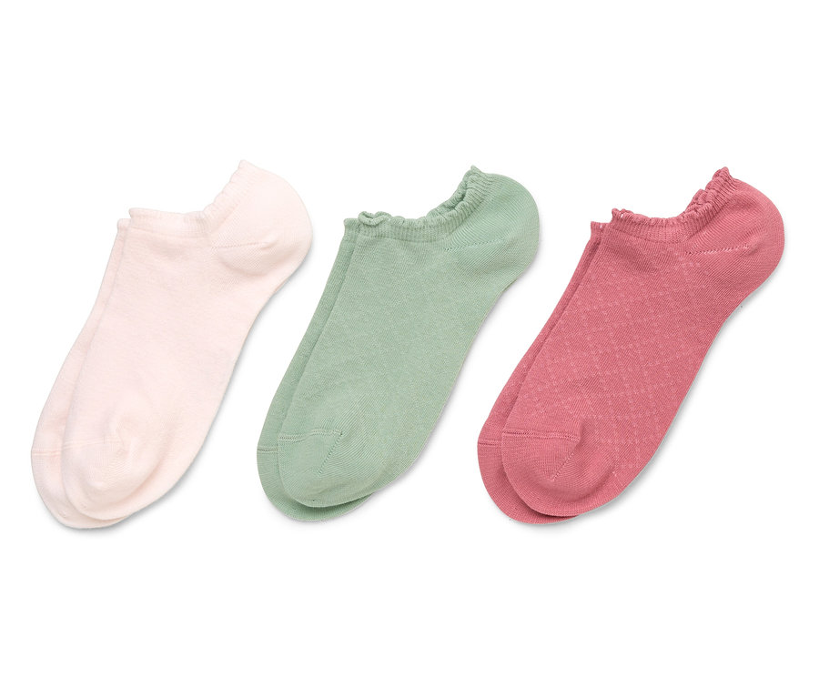 Trois paires de chaussettes basses rose, verte et rouge sont posées sur un fond blanc.