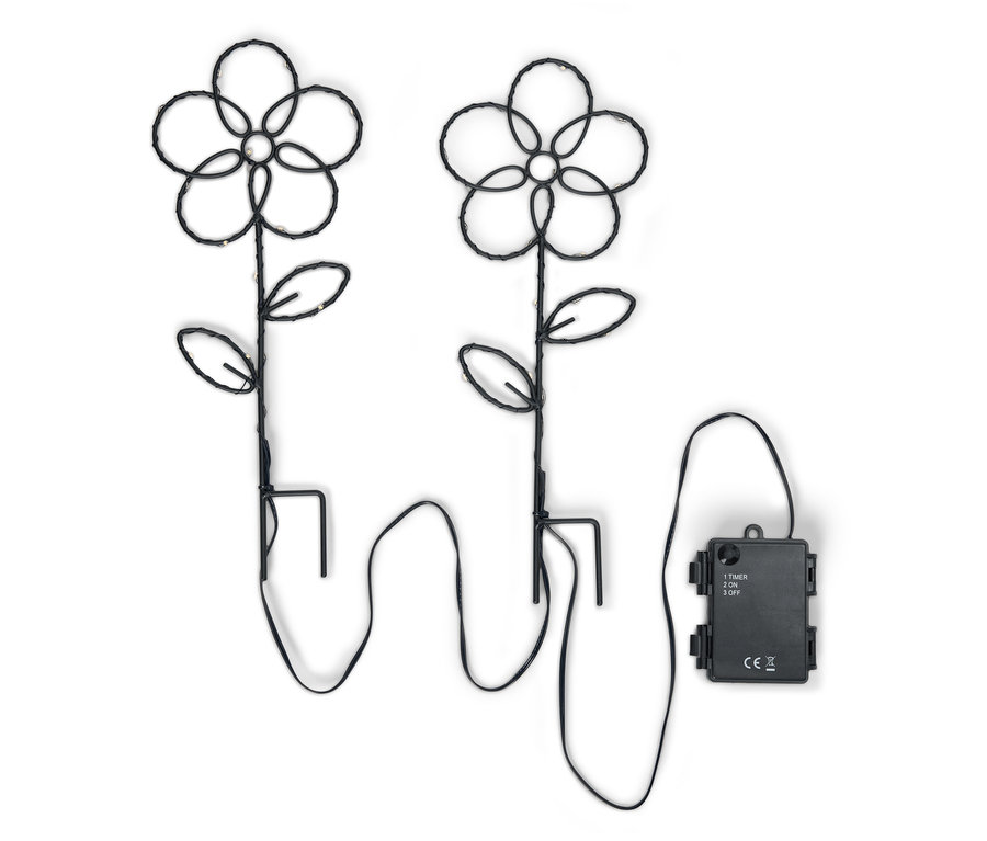 Deux lampes de jardin à fleurs noires avec des lumières LED et un boîtier de batterie sur un fond blanc.