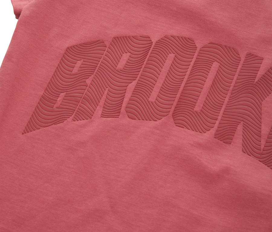 Gros plan d'un t-shirt rose avec le mot BROOK en relief.