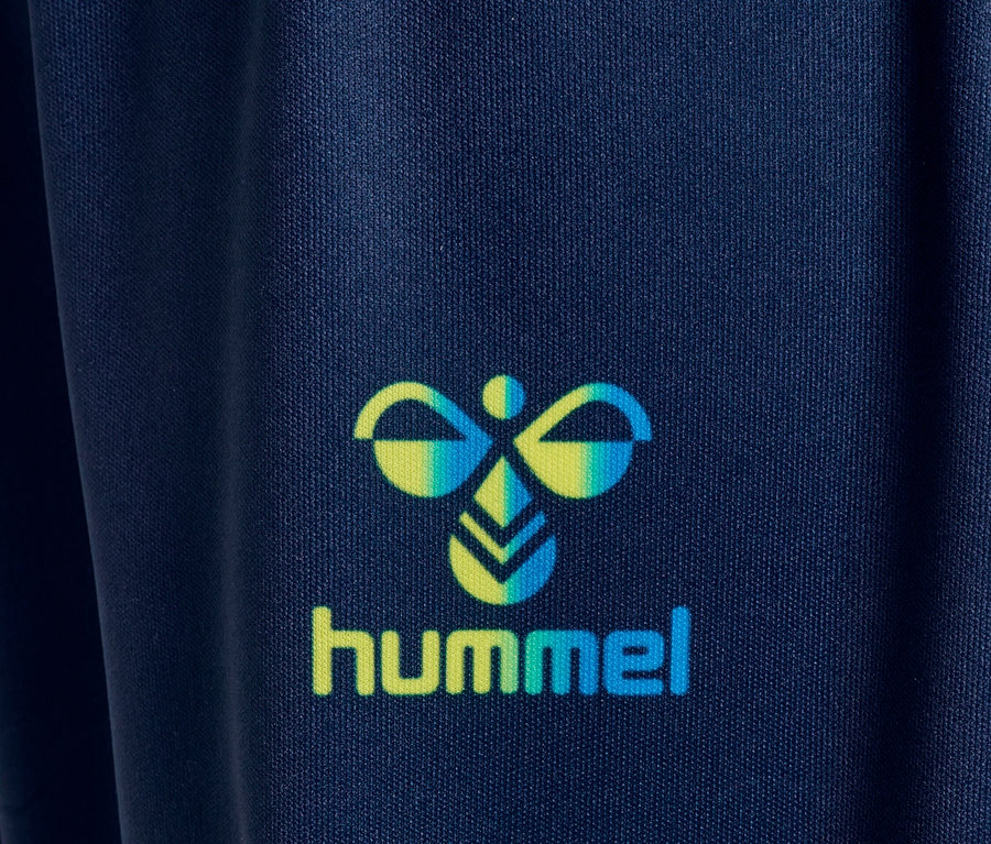 Gros plan du logo Hummel sur un tissu bleu marine.