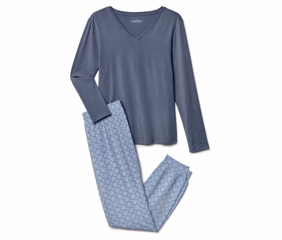 Un haut bleu à manches longues et col en V et un pantalon bleu clair à motifs sont posés l'un à côté de l'autre.