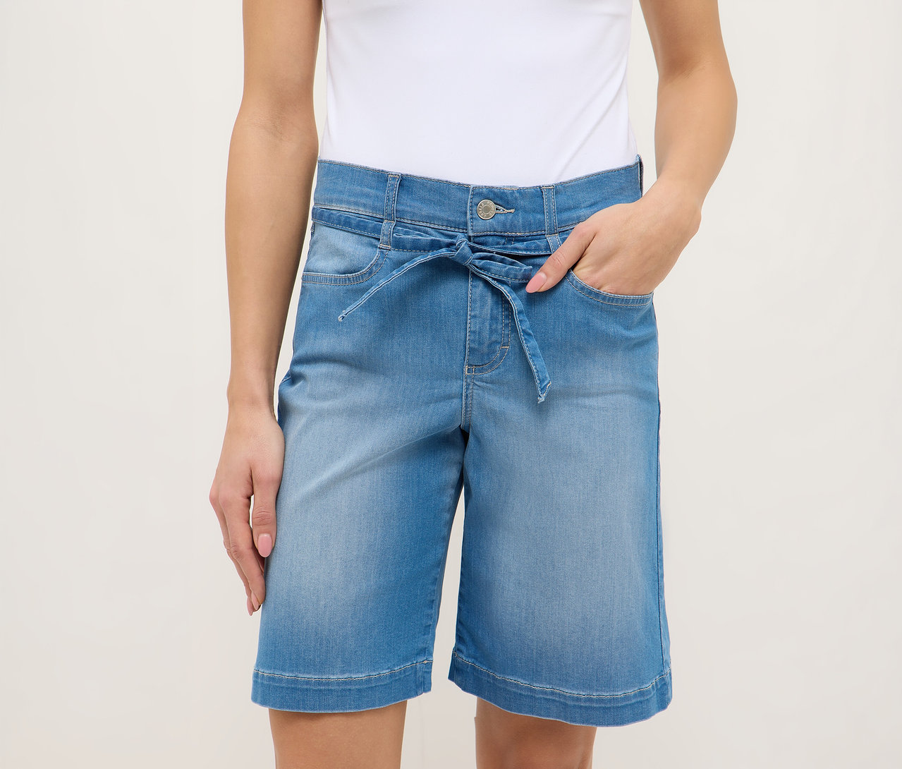 Femme portant un short Angels Denim «
Lia City
» bleu clair avec une ceinture à nouer et un débardeur blanc.