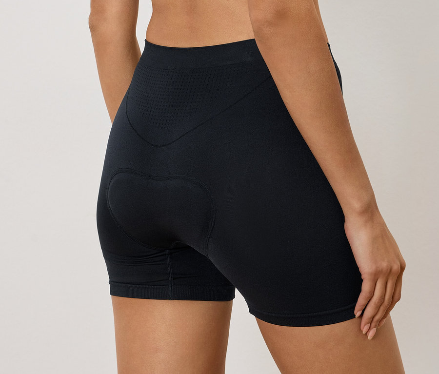 Femme portant un short de cycliste noir avec rembourrage aux fesses, vue de dos.
