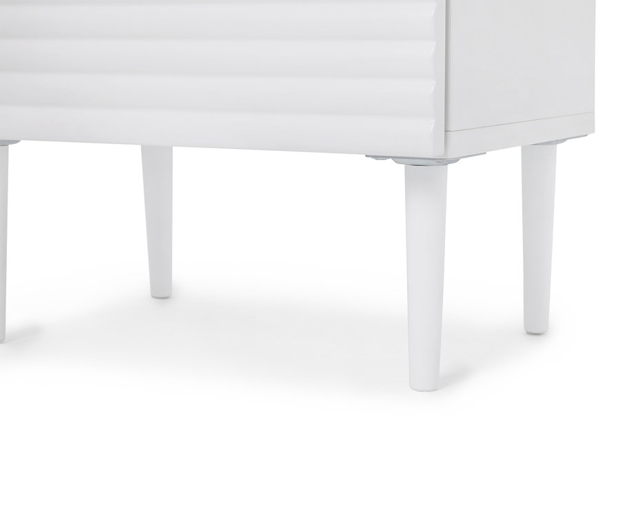 Gros plan sur une table de chevet blanche au design simple et dotée de quatre pieds coniques.