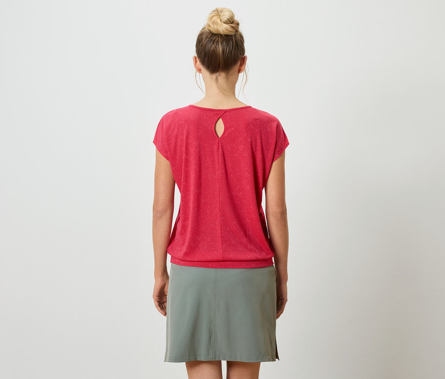 Vue arrière d'une femme portant un chignon, un t-shirt rouge avec une ouverture en trou de serrure et une jupe grise sur un fond blanc.