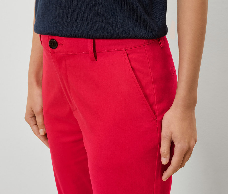 Gros plan d'une femme portant un pantalon rouge et une chemise bleue.