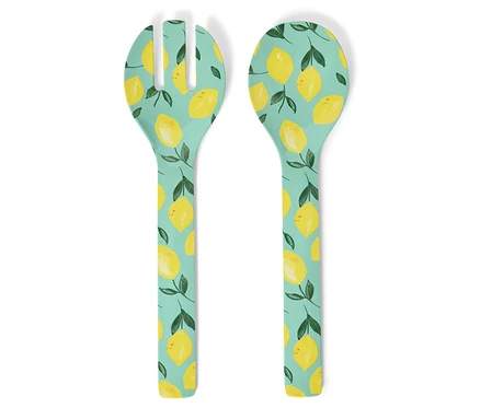 Vue de dessus d'un service à salade avec un motif de citrons sur un fond bleu clair.