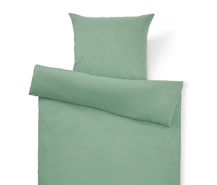 Vue de dessus d'un ensemble de housse de couette vert clair uni avec oreiller et housse de couette.