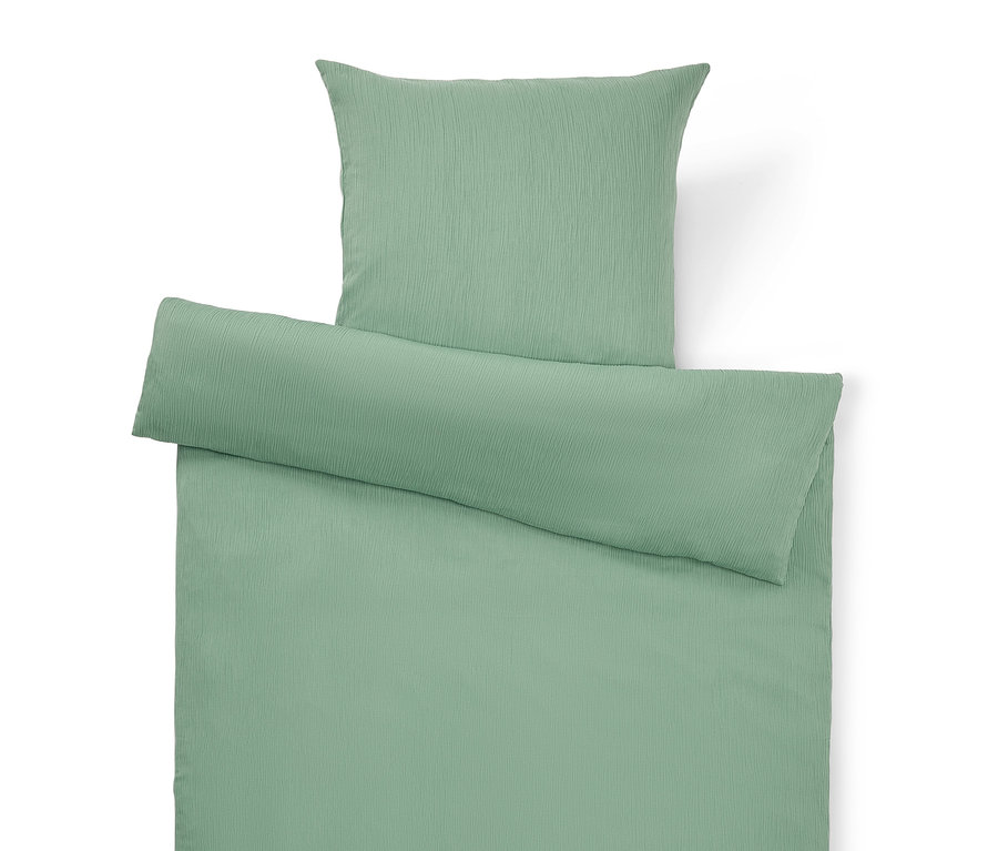 Vue de dessus d'un ensemble de housse de couette vert clair uni avec oreiller et housse de couette.