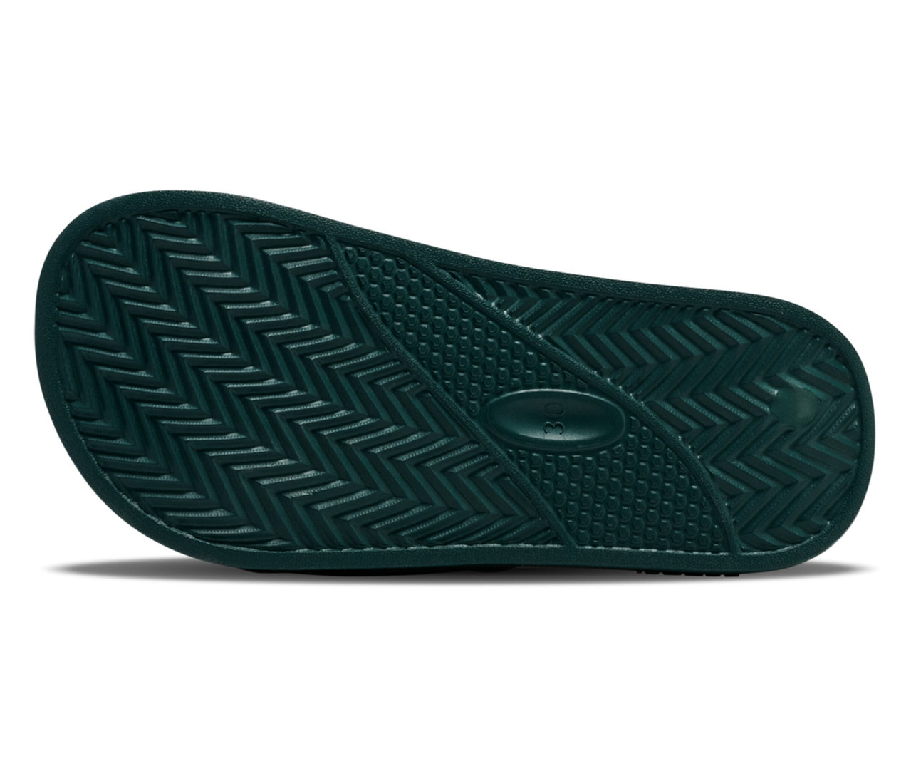 Gros plan sur la semelle d'une tong de bain verte hummel® Pool Slide JR avec motif rainuré.