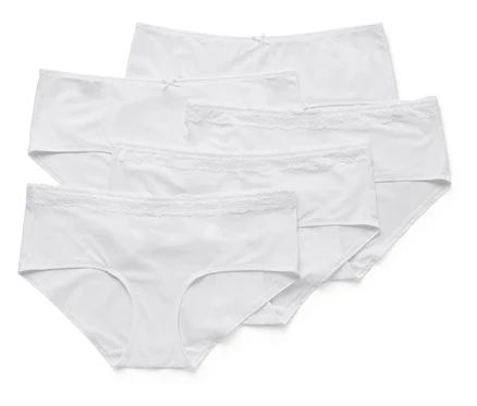 Cinq culottes blanches pour femmes sont posées les unes sur les autres, certaines avec des bordures en dentelle.