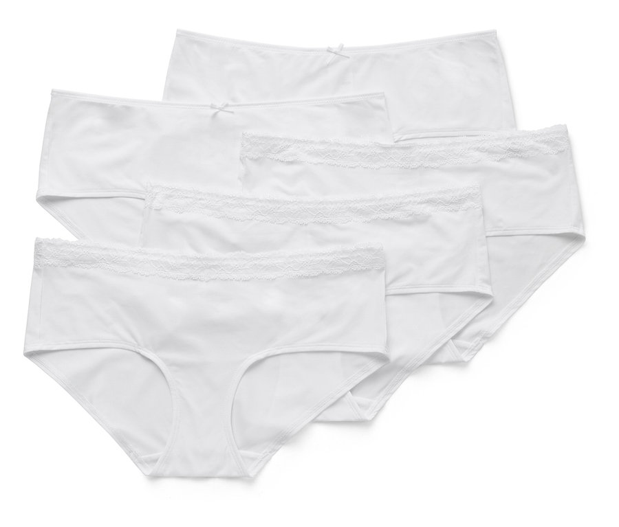 Cinq culottes blanches pour femmes sont posées les unes sur les autres, certaines avec des bordures en dentelle.
