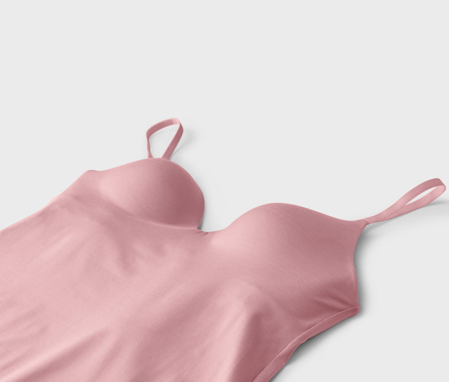 Gros plan d'un débardeur soutien-gorge rose à bretelles spaghetti sur fond blanc.