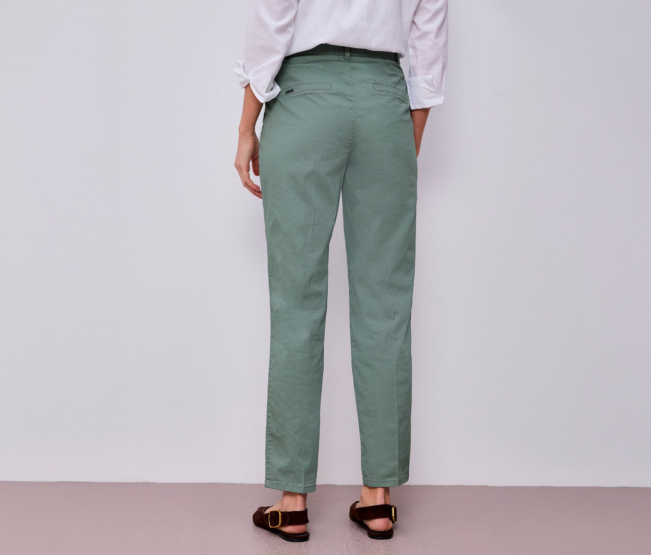 Vue arrière d'une femme portant une chemise blanche et un chino menthe Street One, avec des sandales marron.