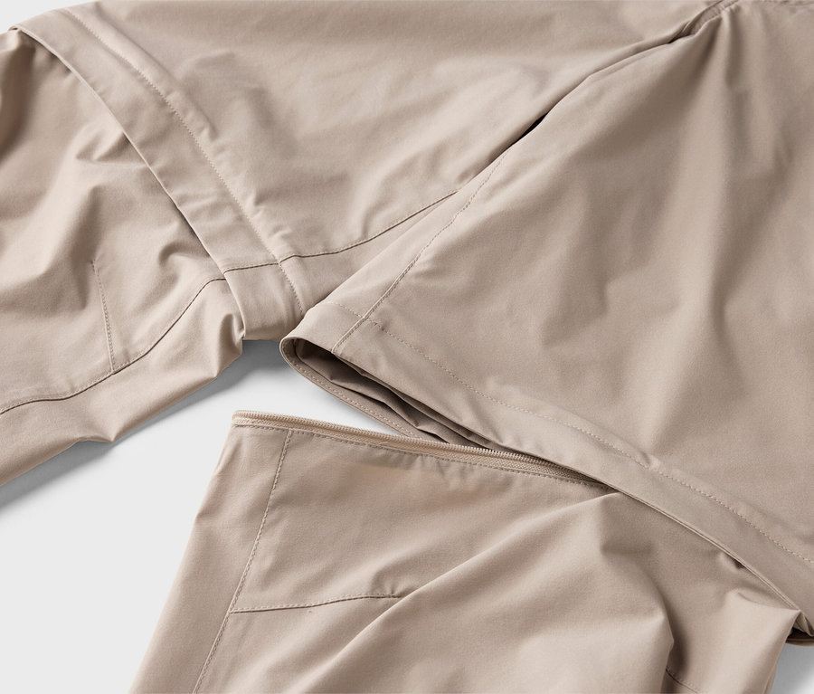 Gros plan d'un pantalon en tissu beige avec une jambe amovible.