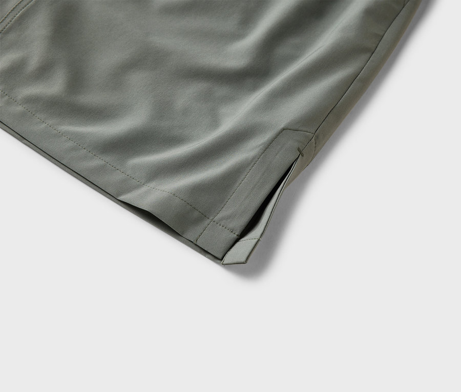 Gros plan sur un pantalon en tissu vert olive avec une poche latérale.