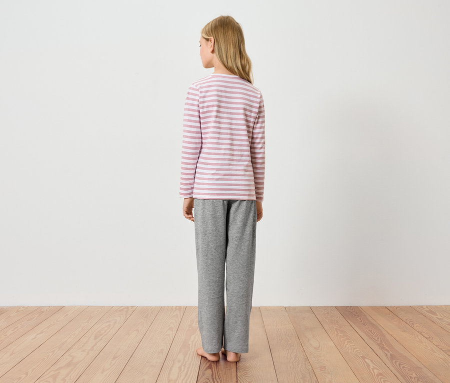 Fille vue de dos, portant un t-shirt à manches longues rayé et un pantalon gris.