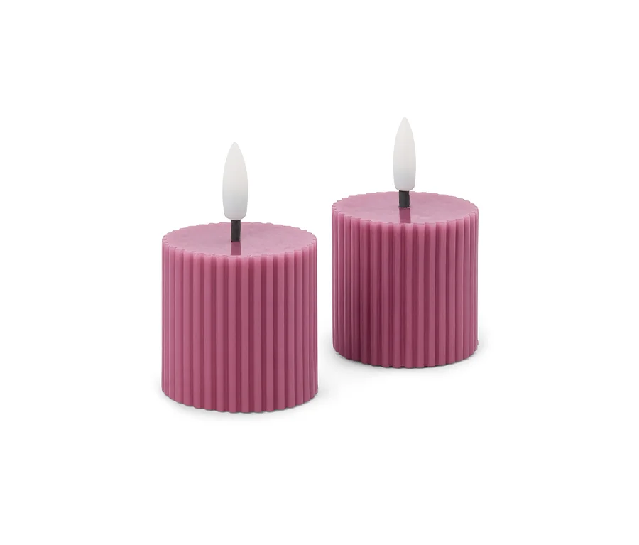 Deux bougies LED cylindriques courtes, rose foncé, avec une texture côtelée et des flammes blanches sur fond blanc.