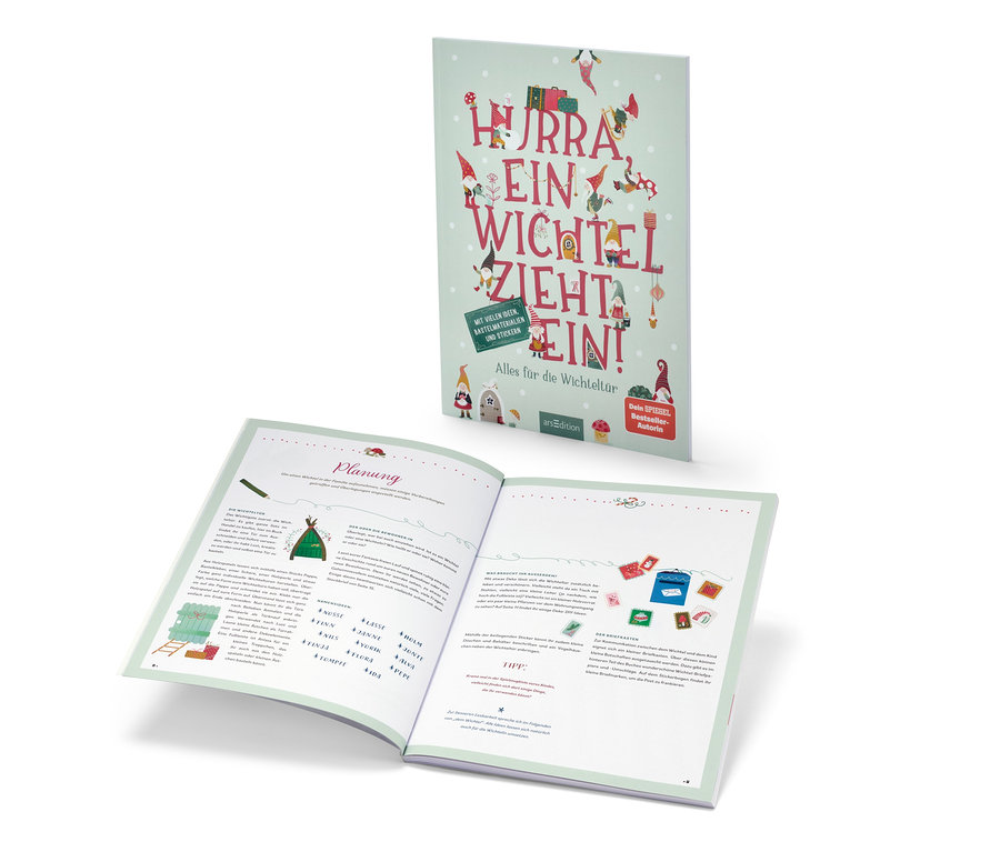 Le livre « Hurra, ein Wichtel zieht ein! » (en allemand) est ouvert et se trouve derrière.
