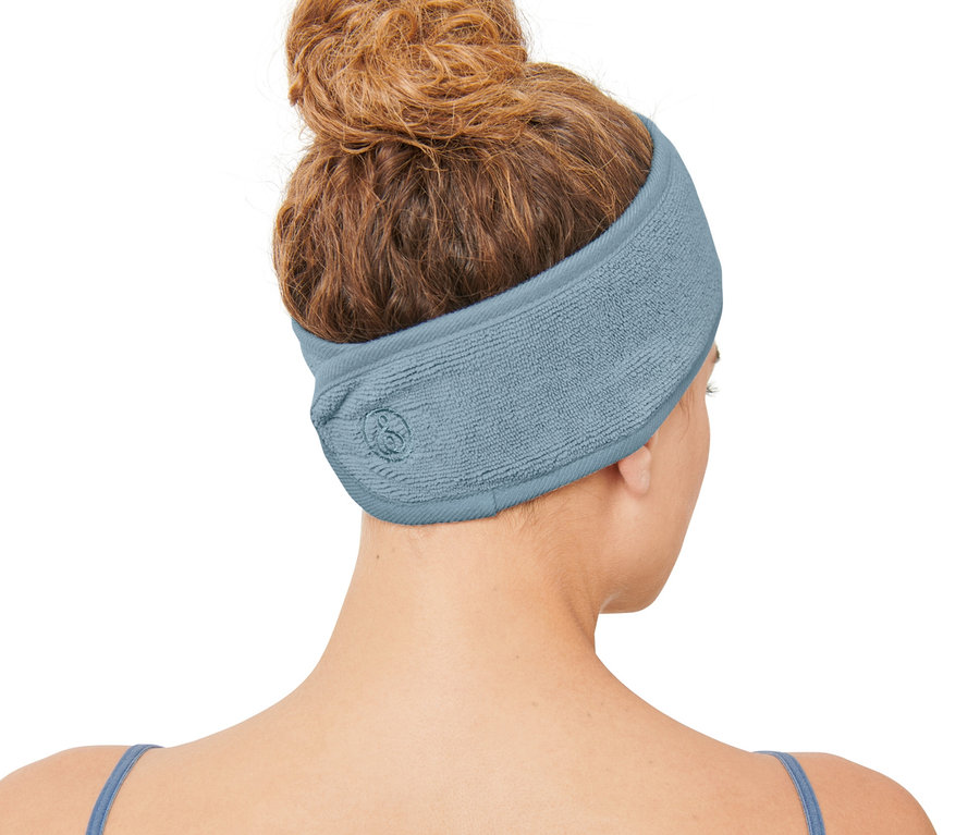 Une femme vue de dos avec un chignon portant 2 bandeaux cosmétiques.